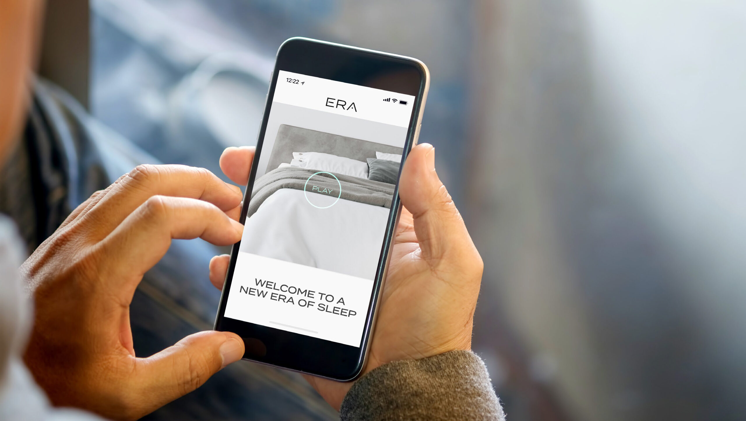 Man holding smart phone with blurred background.